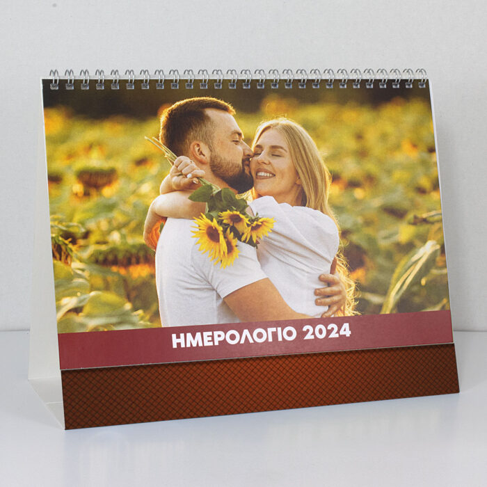 Επιτραπέζιο Ημερολόγιο Επιτραπέζιο ημερολόγιο με φωτογραφία ενός χαρούμενου ζευγαριού που στέκεται μέσα σε λιβάδι γεμάτο ηλιοτρόπια, με φωτεινό και ζεστό φόντο.